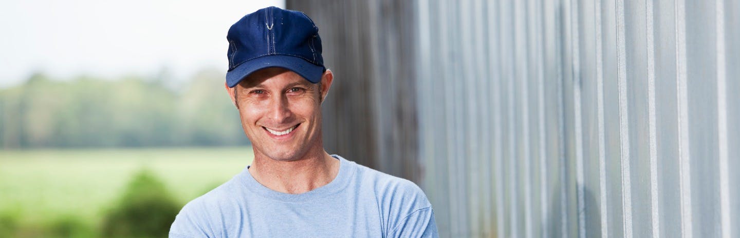 smiling-man-in-cap-standing-outside-building-picture-id171316905